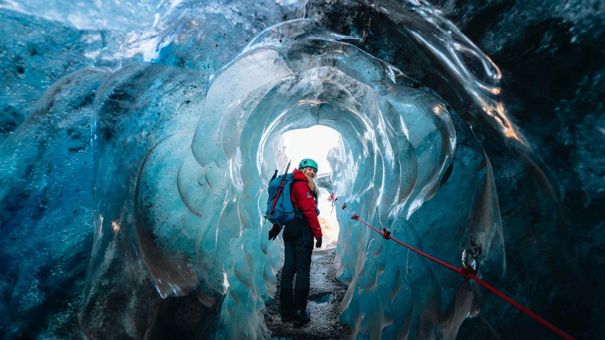 Hikers in crampons crossing Falljökull towards a blue ice cave on a Skaftafell Iceland ice cave day tour